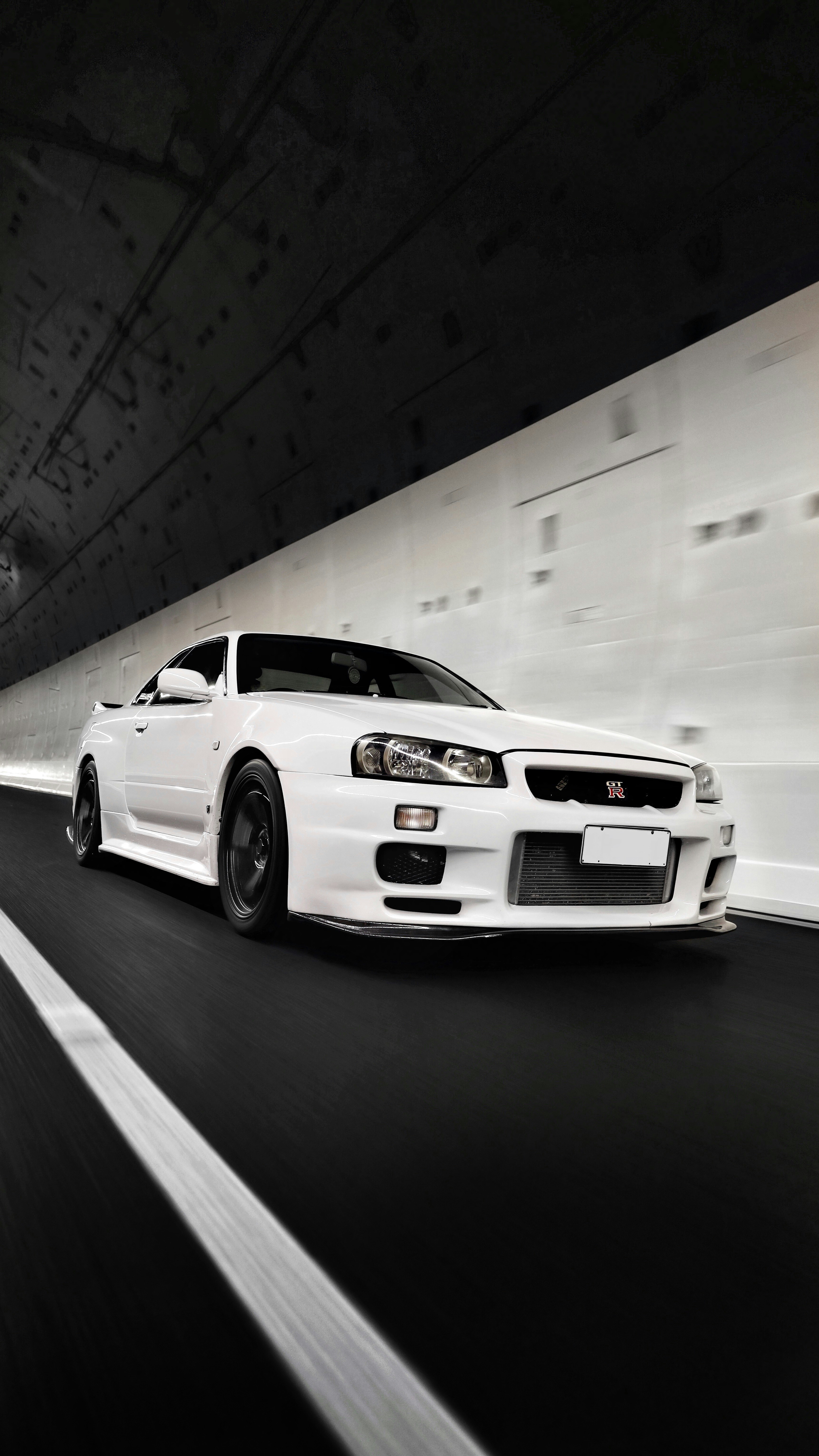 Nissan Skyline blanco en túnel moderno a alta velocidad