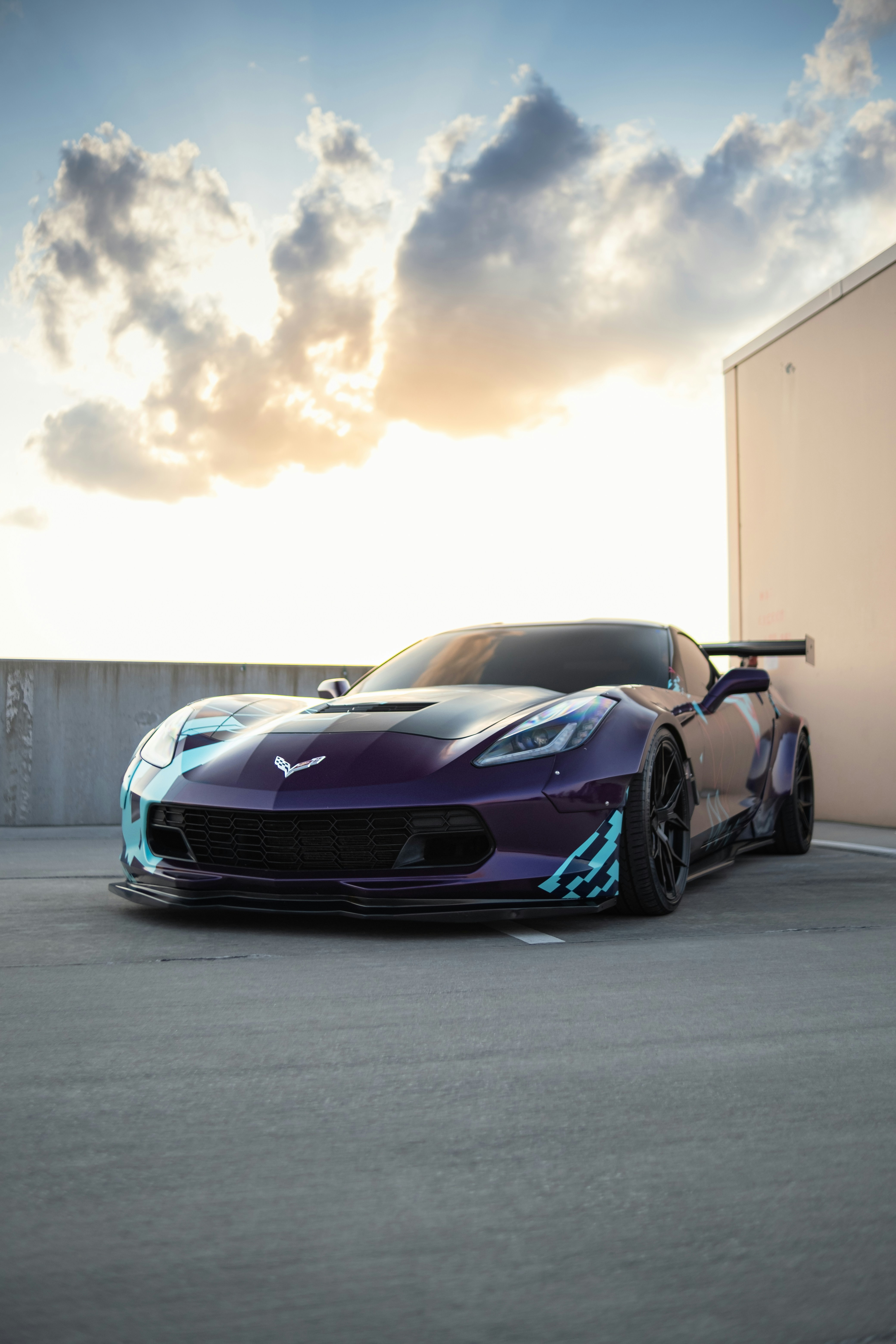 Corvette deportivo púrpura con cielo al atardecer